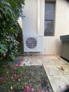Outdoor AC unit installed on wall brackets